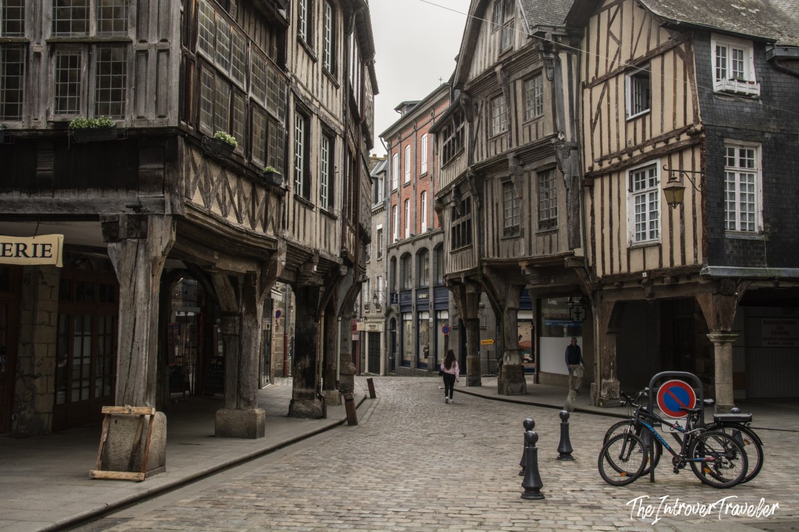 Cobblestone street lined with medieval half-timbered houses in Dinan, Brittany, France