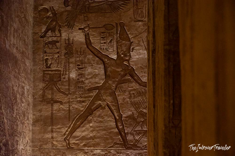 Ancient Egyptian relief carving at Abu Simbel showing Ramesses II smiting enemies, surrounded by hieroglyphs