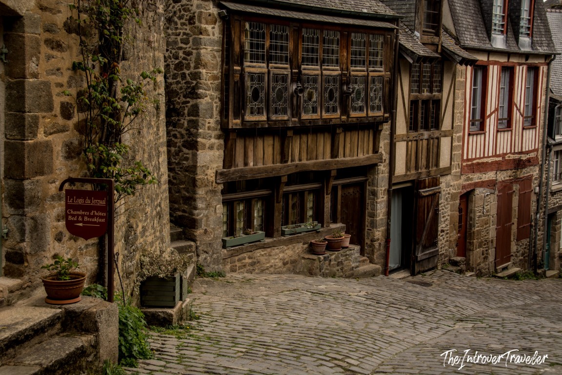 Cobblestone Rue du Jerzual in Dinan, lined with medieval half-timbered houses and a B&B sign