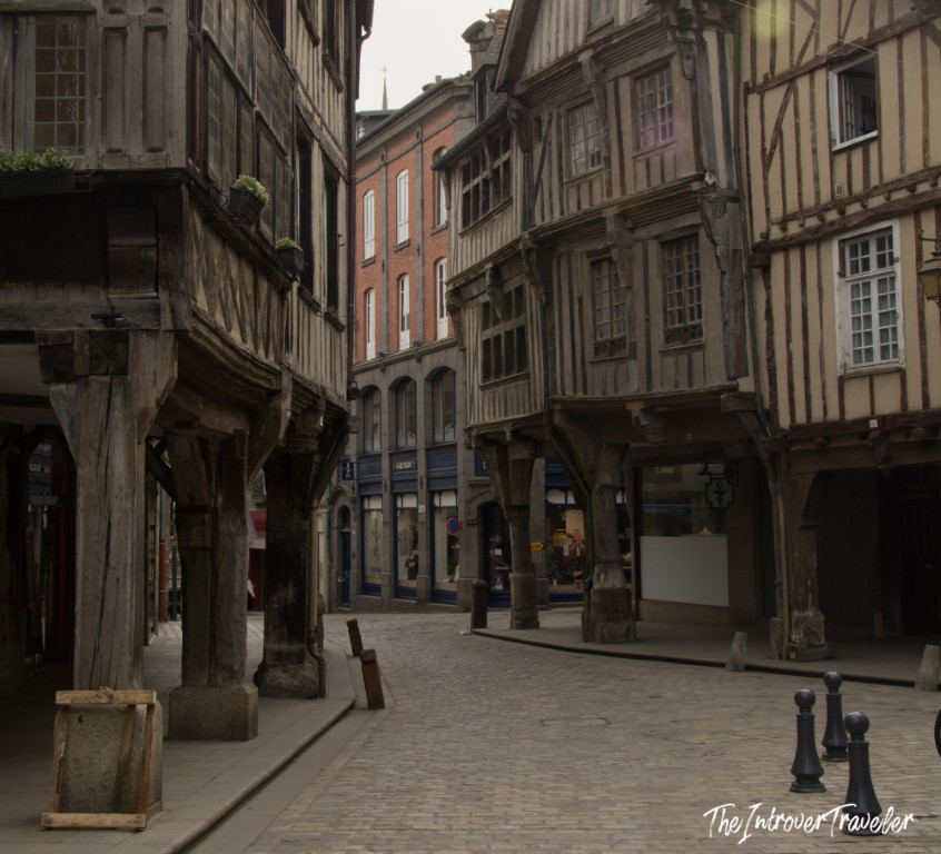 Cobblestone street lined with medieval half-timbered buildings in the old town of Dinan, France