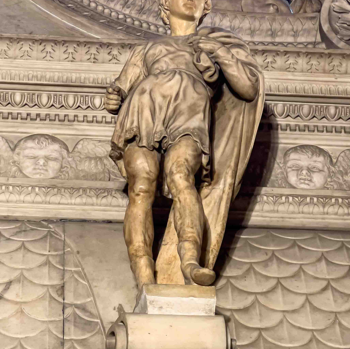 Figurine atop the Ark of Saint Dominic, Bologna, with cherub reliefs and ornate marble carved decoration