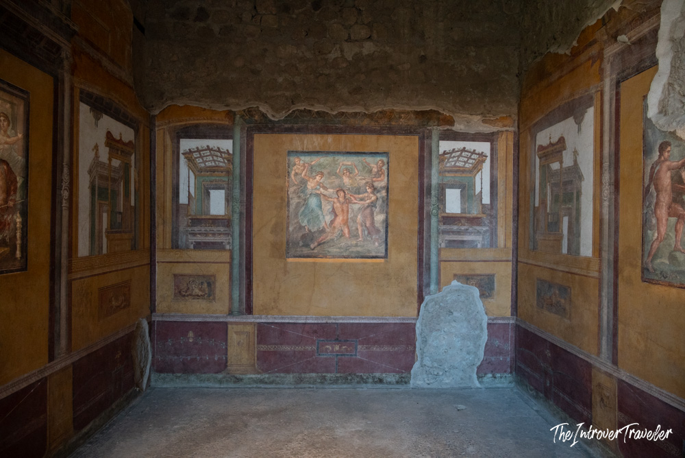 Richly painted Roman frescoes covering walls of a preserved room in ancient Pompeii