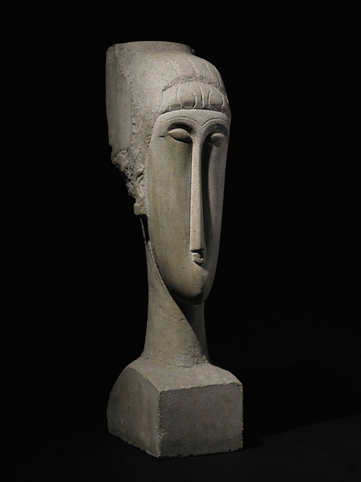 Elongated stone head sculpture by Modigliani, echoing the stylized faces of the Giants of Mont'e Prama