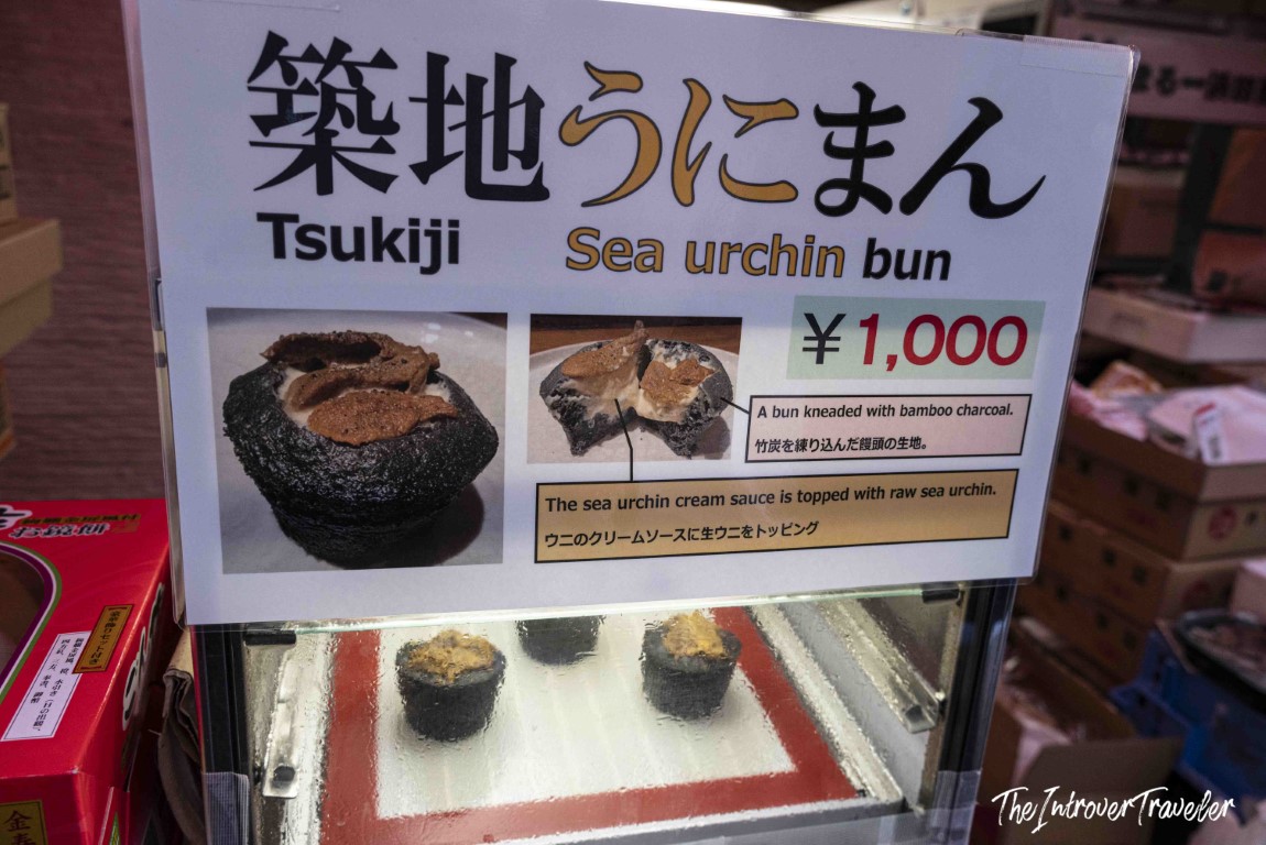 Tsukiji market sea urchin bun sign, bamboo charcoal bun topped with raw uni, priced at 1000 yen