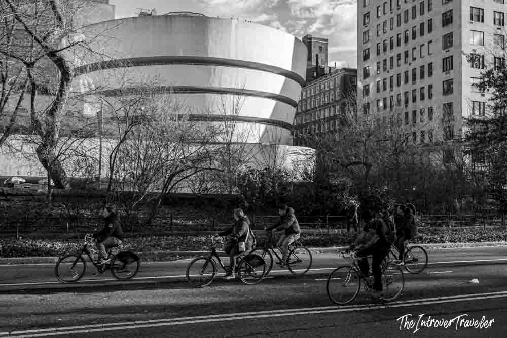 Cyclists riding past the Solomon R. Guggenheim Museum on Fifth Avenue, New York City