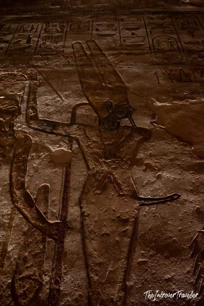 Ancient Egyptian god relief carving with hieroglyphs on the inner walls of Abu Simbel temple