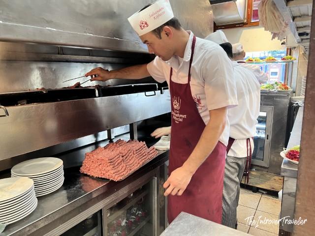 Cook grilling köfte at Sultanahmet Köftecisi, Istanbul's legendary meatball restaurant near Hagia Sophia