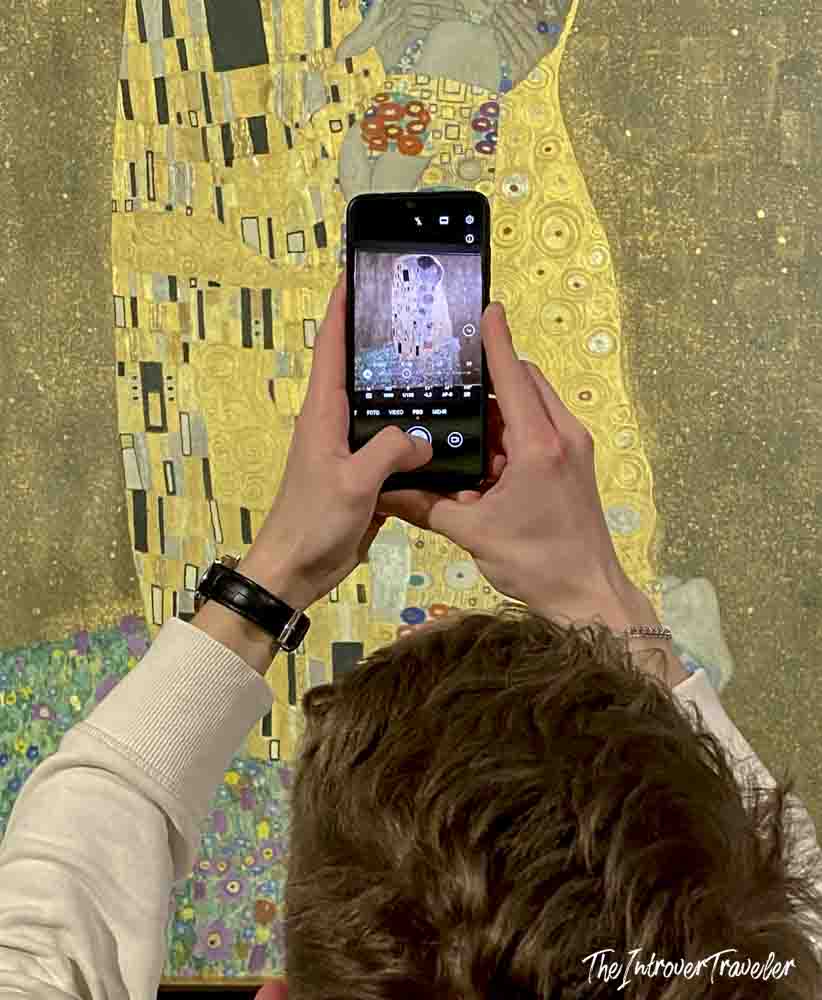 Visitor photographing The Kiss by Gustav Klimt at the Belvedere Museum in Vienna