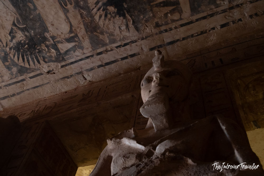 Interior pillar statue of Ramesses II inside Abu Simbel temple, with hieroglyph-covered ceiling above