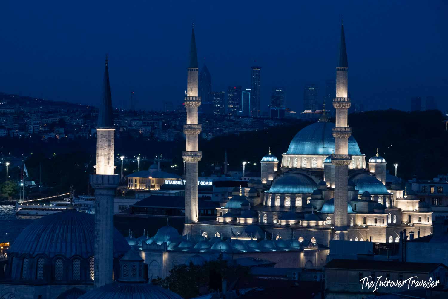 Süleymaniye Mosque illuminated at night against the Istanbul skyline, with minarets and domes glowing