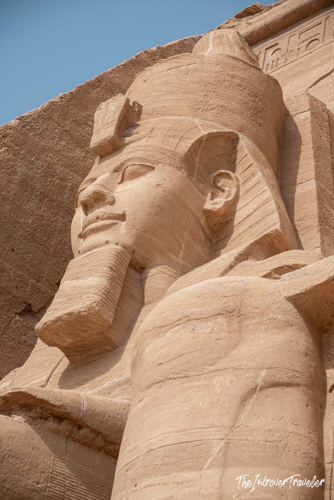 Close-up of a colossal Ramesses II sandstone statue at the Abu Simbel temple facade, Egypt