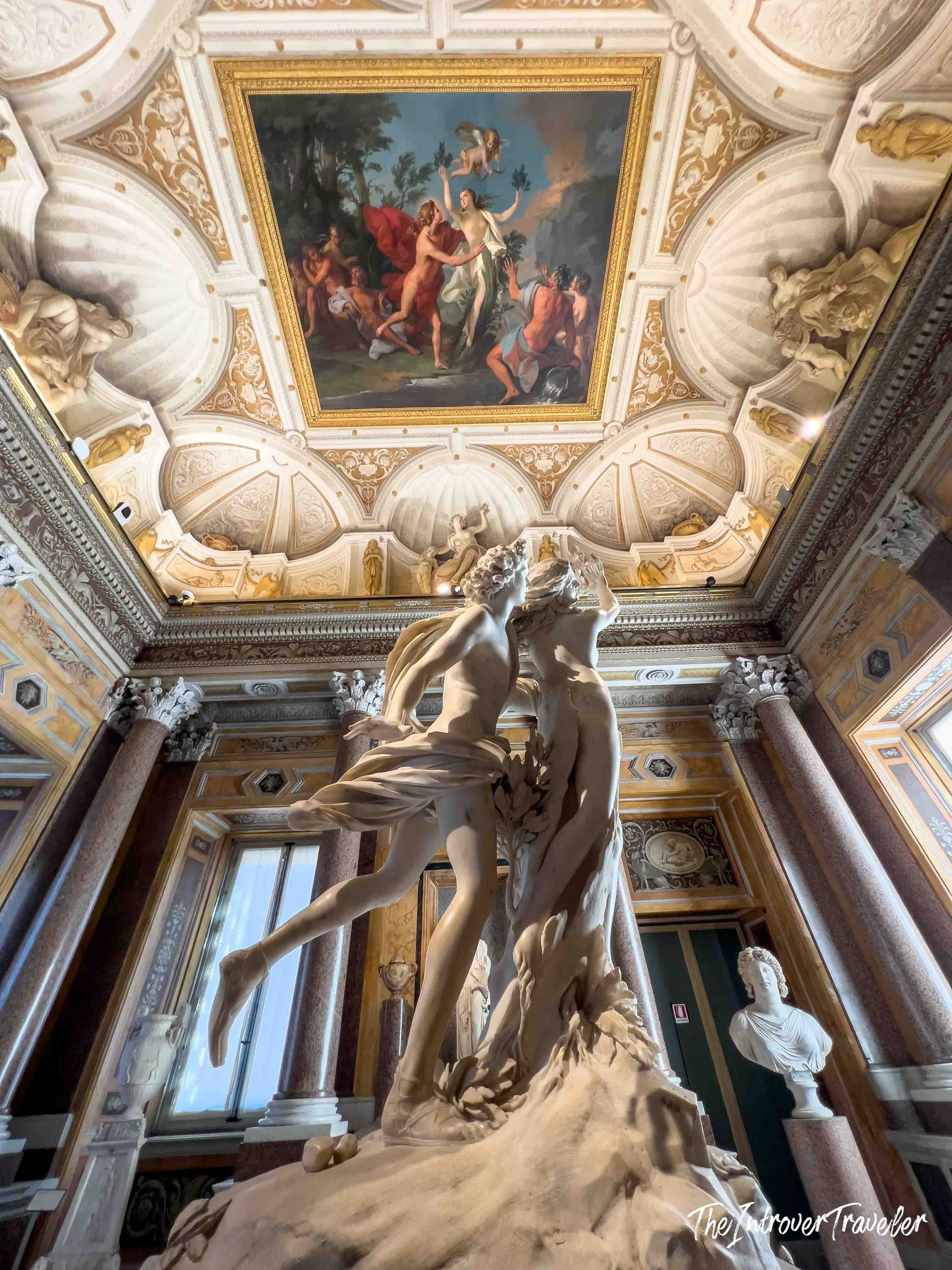 Bernini's Apollo and Daphne at Borghese Gallery, Rome, beneath ornate frescoed ceiling