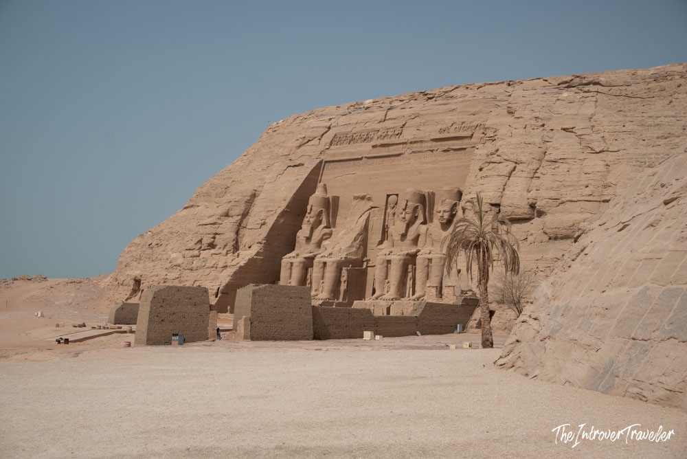 Abu Simbel temple facade with four colossal seated statues of Ramesses II carved into the sandstone cliff, Egypt