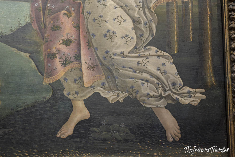 Close-up of the flowing floral dress and bare feet in Botticelli's Primavera at the Uffizi Gallery, Florence
