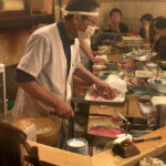 Kame Sushi Sohonten chef preparing Edo-style sushi behind the counter in Namba, Osaka