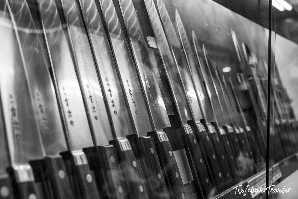 Row of Japanese kitchen knives with kanji engravings displayed at Tsukiji market, Tokyo