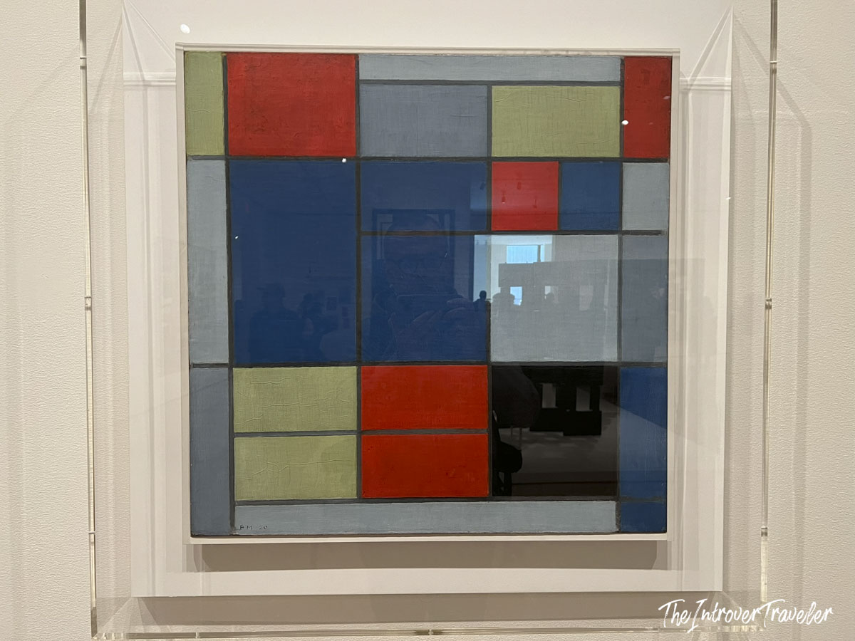 Mondrian abstract grid painting with red, blue, and green blocks displayed at MoMA New York