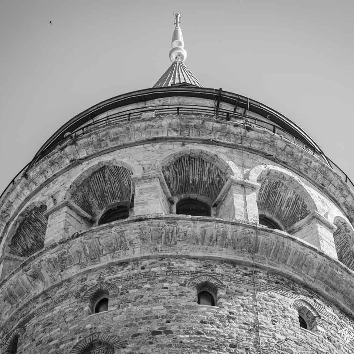 Galata Tower in Istanbul, low-angle black and white view of its conical roof and medieval stonework