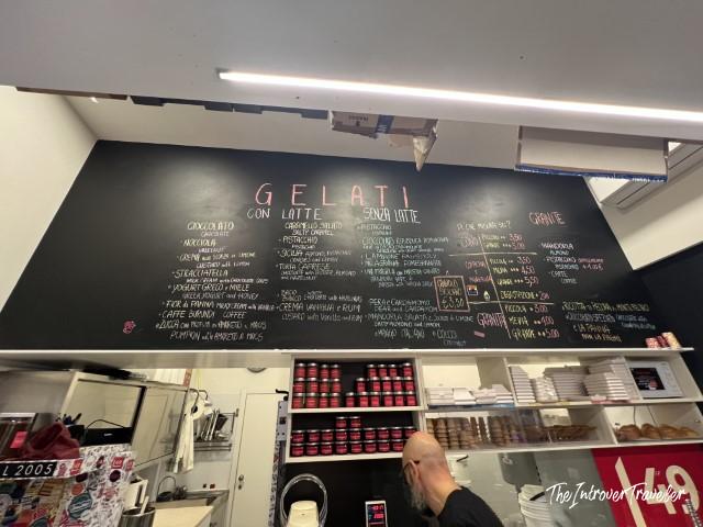 Gelato menu board at a Bologna gelateria showing flavors con latte and senza latte