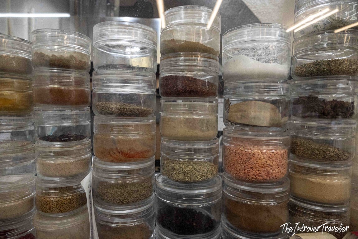 Stacked clear jars of spices, herbs, and lentils at a Tsukiji market vendor in Tokyo