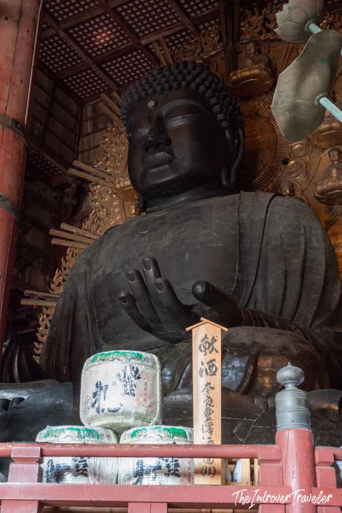 Giant bronze Daibutsu of Todaiji Temple in Nara, with sake barrel offerings at its base