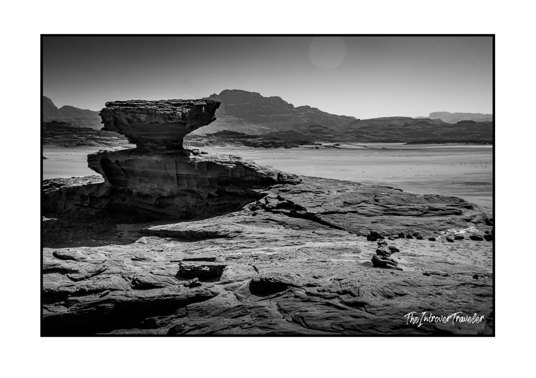 Black and white view of a mushroom-shaped sandstone rock formation in Wadi Rum desert, Jordan