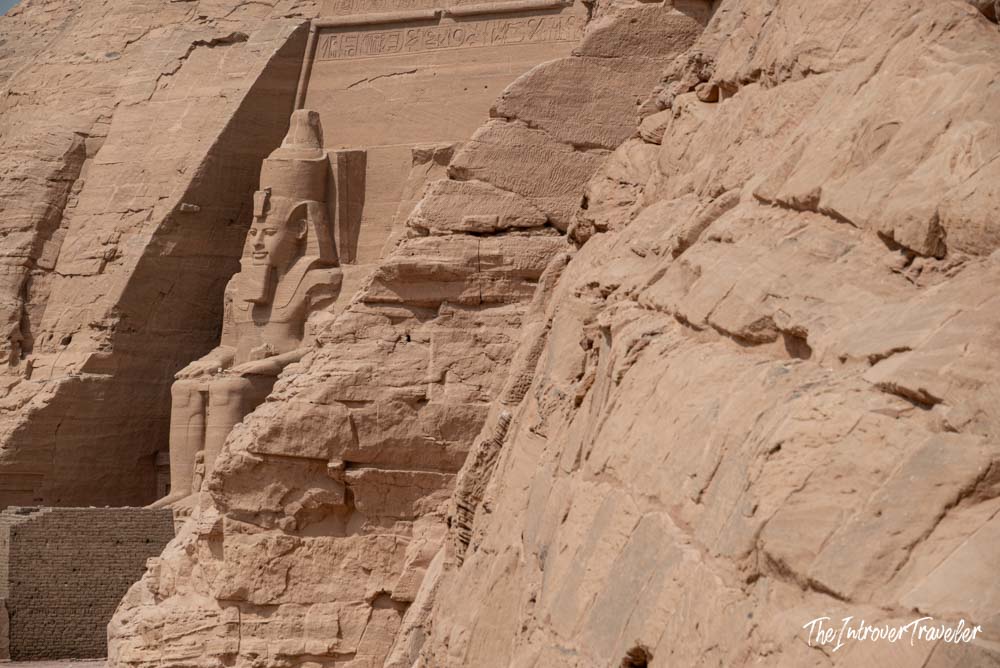 Colossal seated statue of Ramesses II carved into the sandstone facade of Abu Simbel temple, Egypt