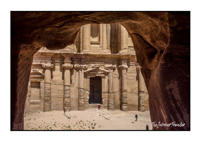 Ad Deir monastery facade in Petra Jordan, framed through a natural rock opening in sandstone cliffs