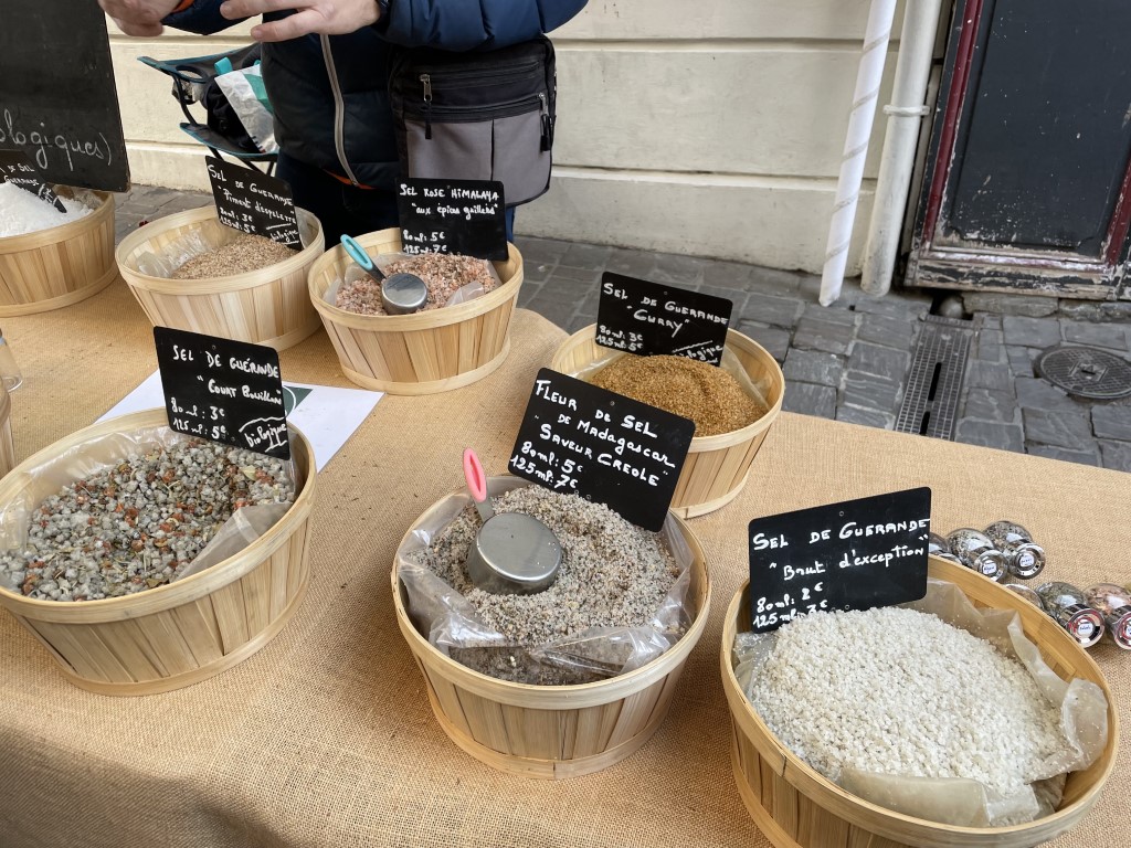 Baskets of Sel de Guérande, fleur de sel, and Himalayan salt at a Honfleur market stall