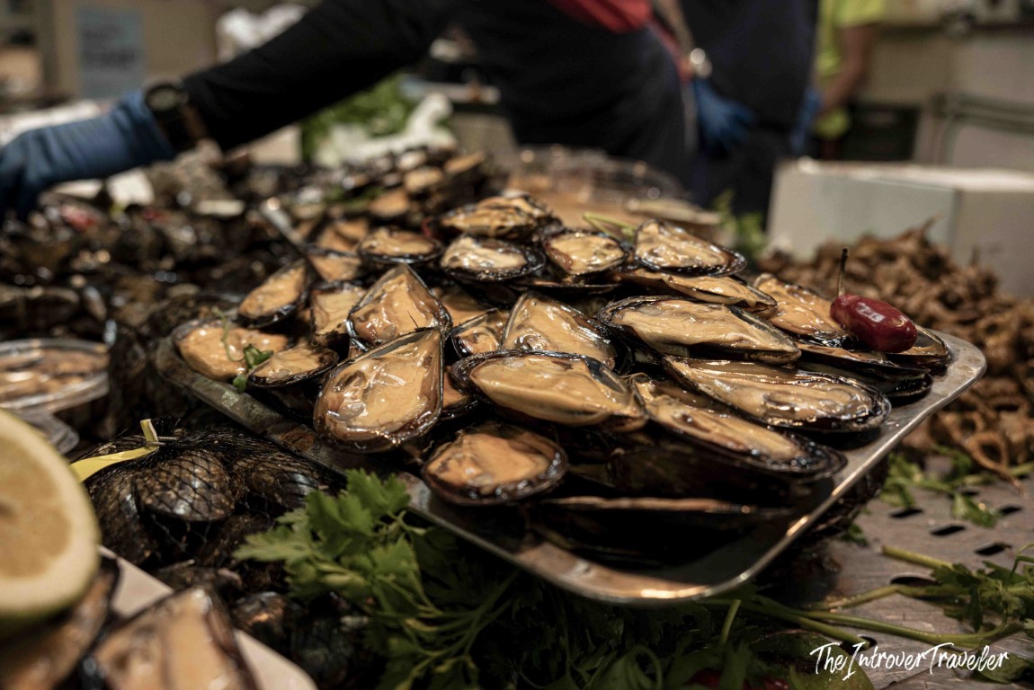 Fresh open mussels piled on a market tray, a coastal fish market staple worldwide
