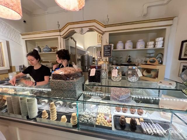 Interior counter at Cremeria Santo Stefano gelateria in Bologna, with staff and a glass display case of gelato