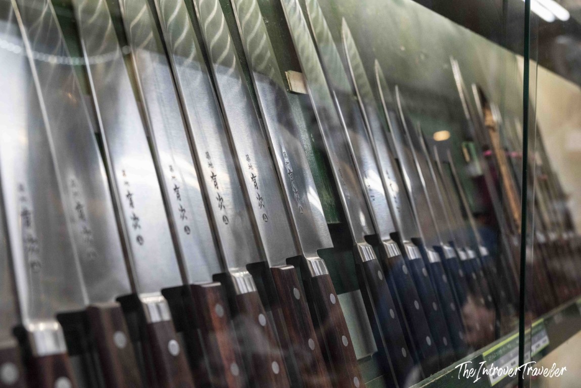 Traditional Japanese knives with kanji engravings displayed in a Tsukiji market shop, Tokyo