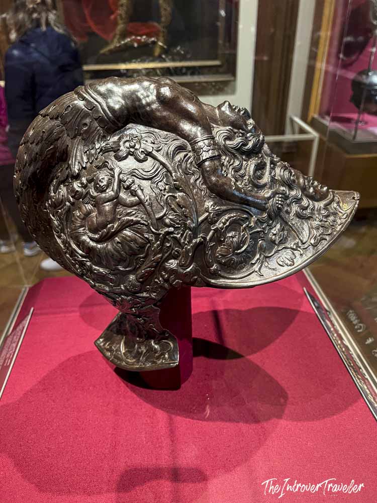Ornate Renaissance ceremonial helmet with embossed figures, on display at the Metropolitan Museum of Art