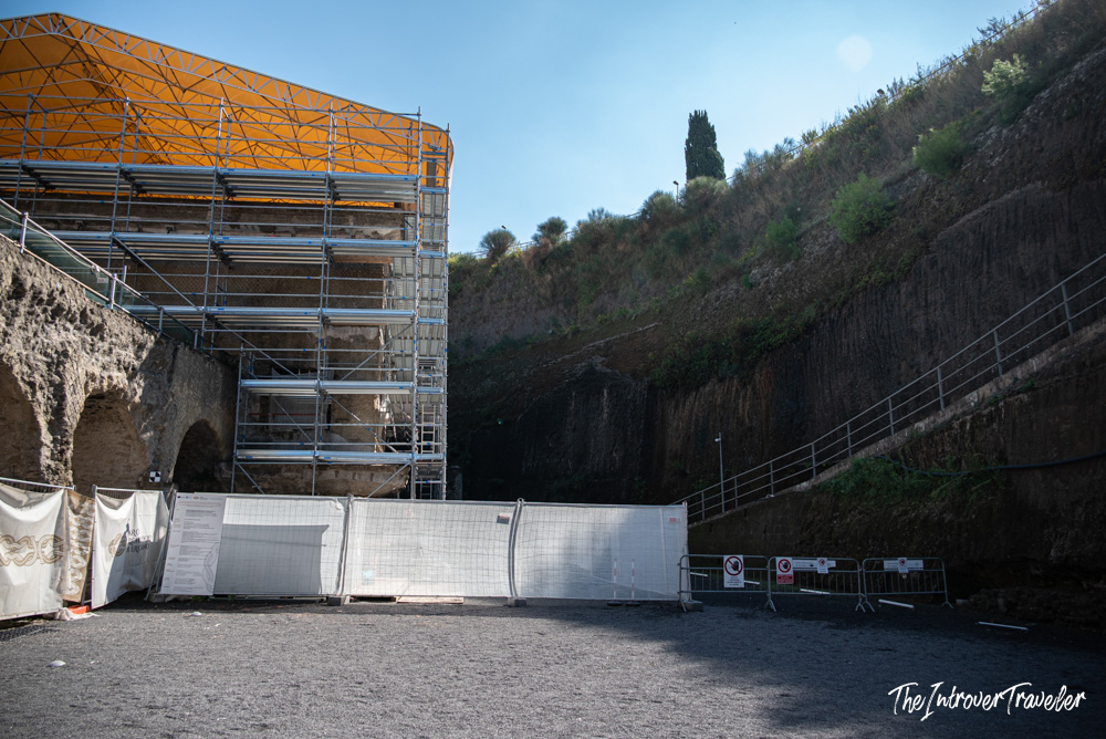 Ancient Roman ruins at Herculaneum under active restoration, with scaffolding and orange protective covering