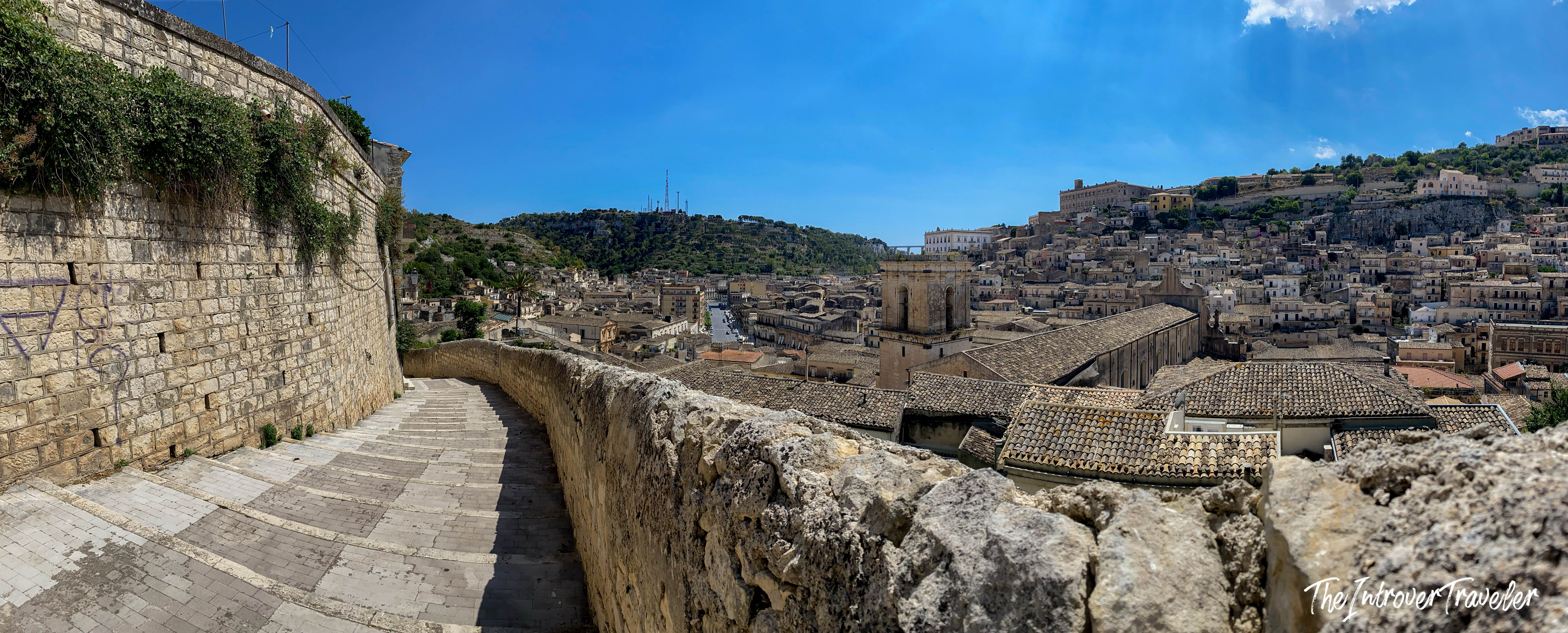 Panoramic view of Modica's Baroque rooftops and hillside town from a stone stairway, Val di Noto Sicily
