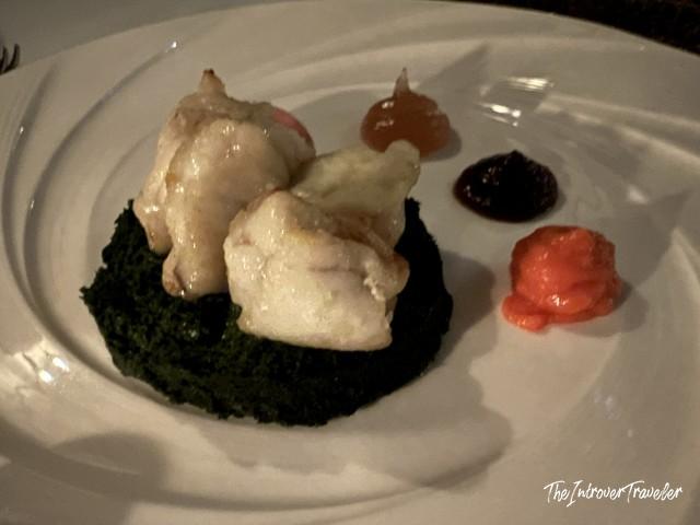 Lokanta 1741 Istanbul fine dining dish with white fish on dark spinach and colorful gel garnishes