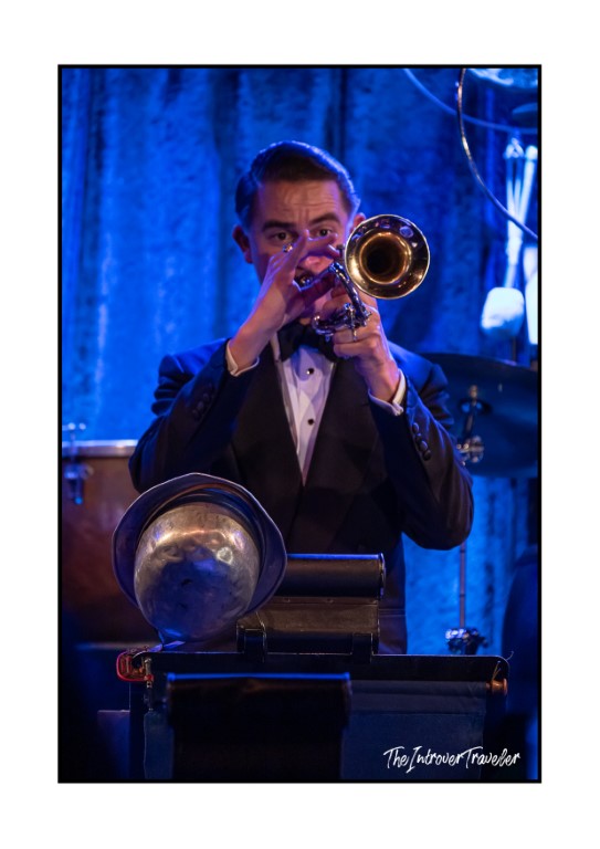 Trumpet player in tuxedo performing live on stage, bathed in blue light, New York 2024