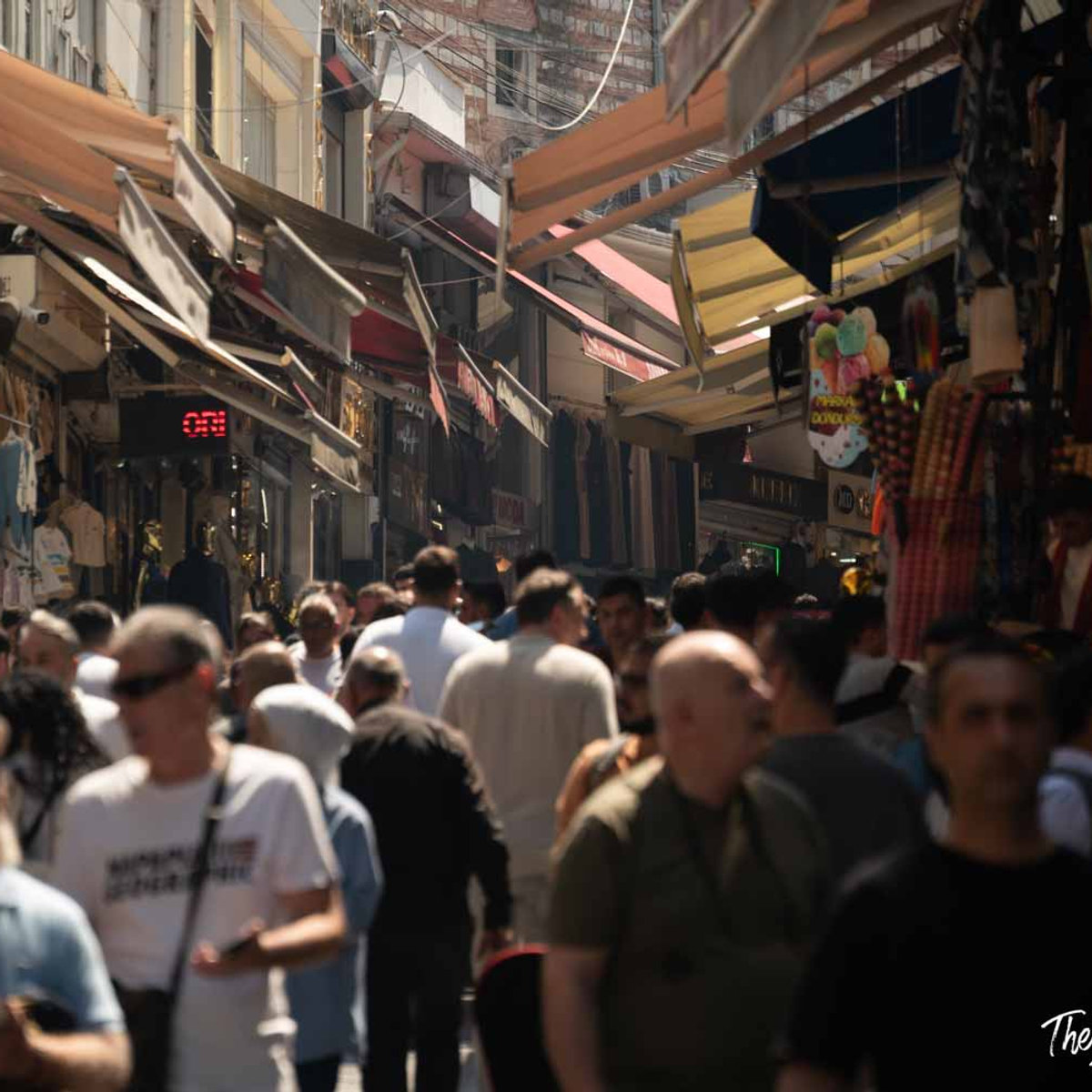 Crowded shopping street in Istanbul's Grand Bazaar area, lined with colorful awnings and local vendors