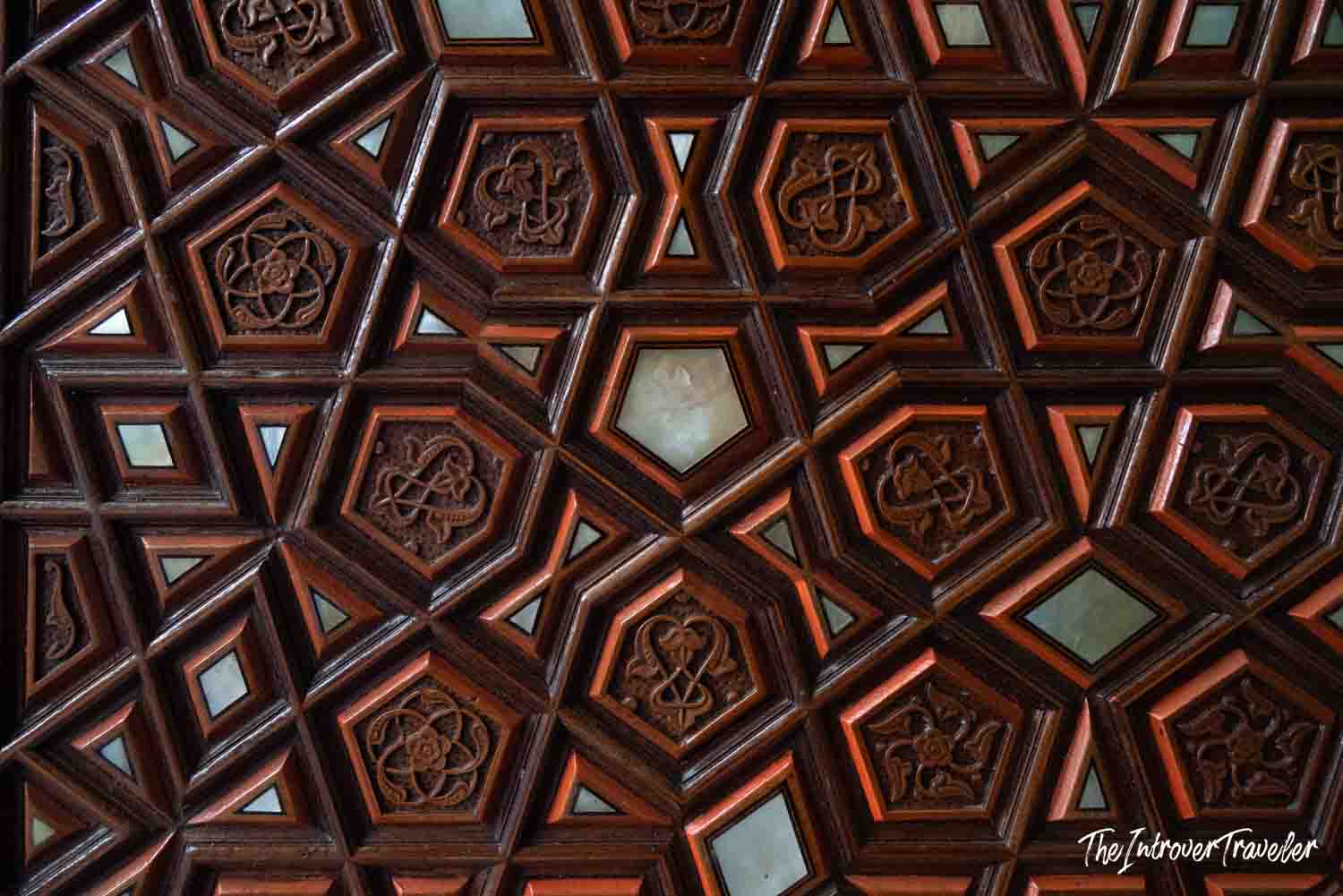 Intricate carved wooden ceiling with geometric Islamic patterns and mother-of-pearl inlays in an Istanbul mosque