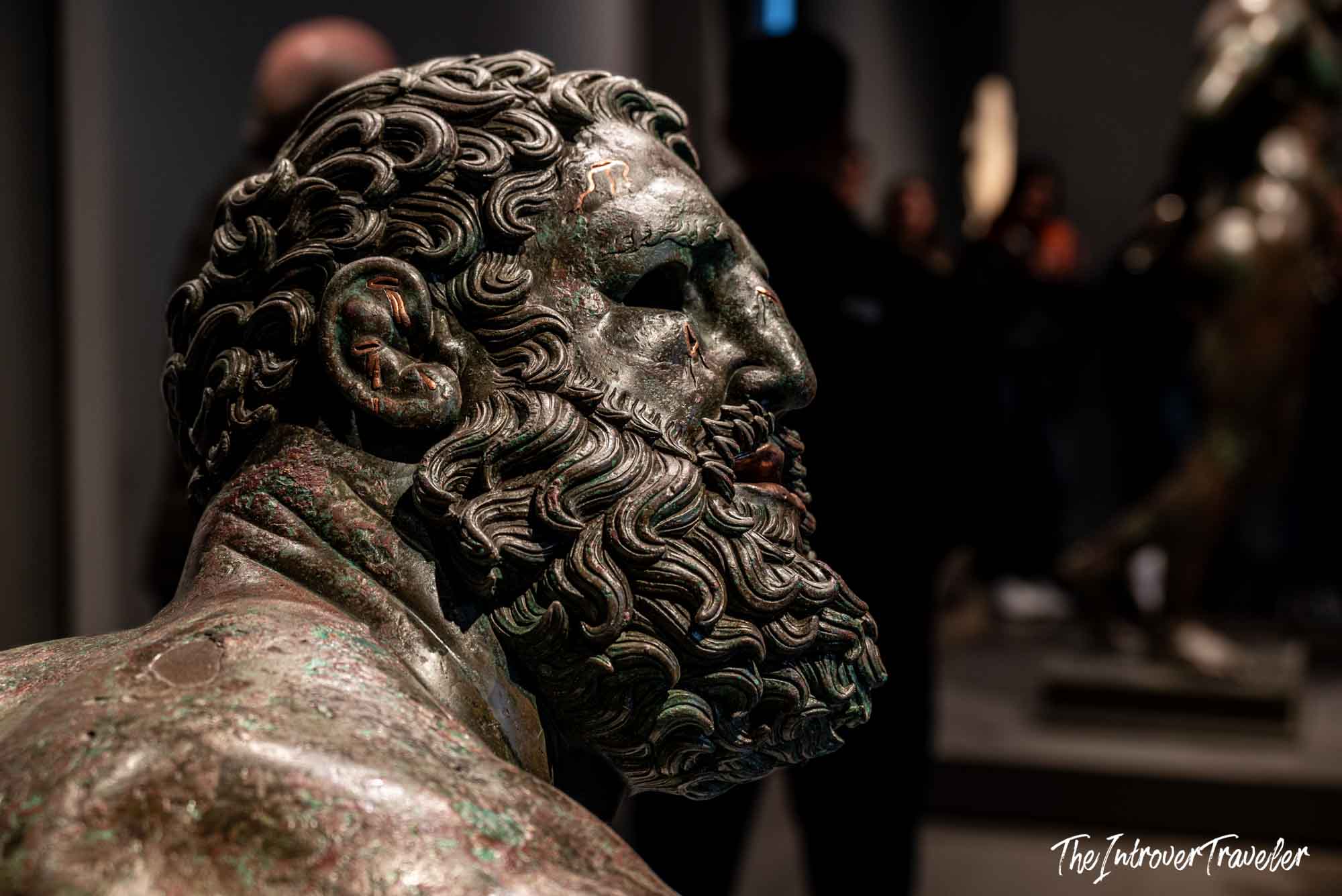Close-up of the Boxer at Rest bronze head, showing detailed curly beard and weathered patina, Palazzo Massimo Rome