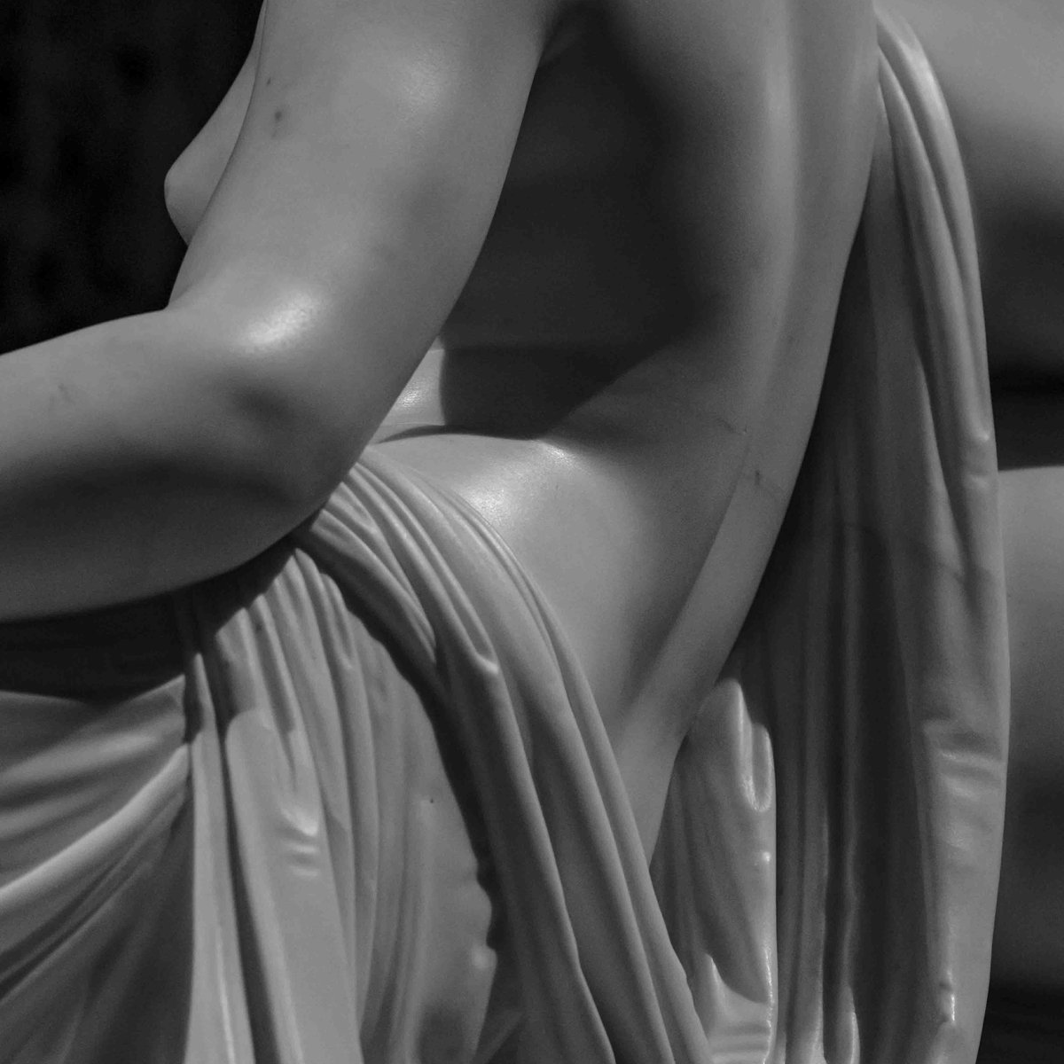 Close-up detail of Canova's Pauline Borghese marble sculpture, showing draped fabric and torso