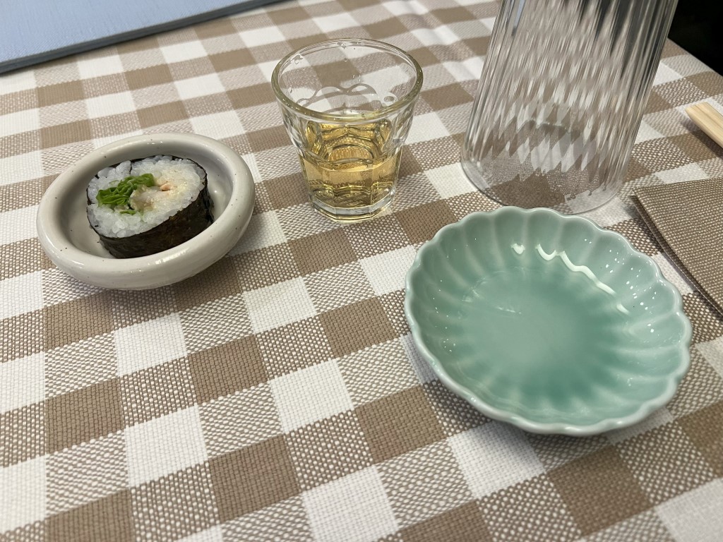 Maki roll with wasabi served at Yuzuya, a Japanese restaurant in Bologna, with sake and celadon dish