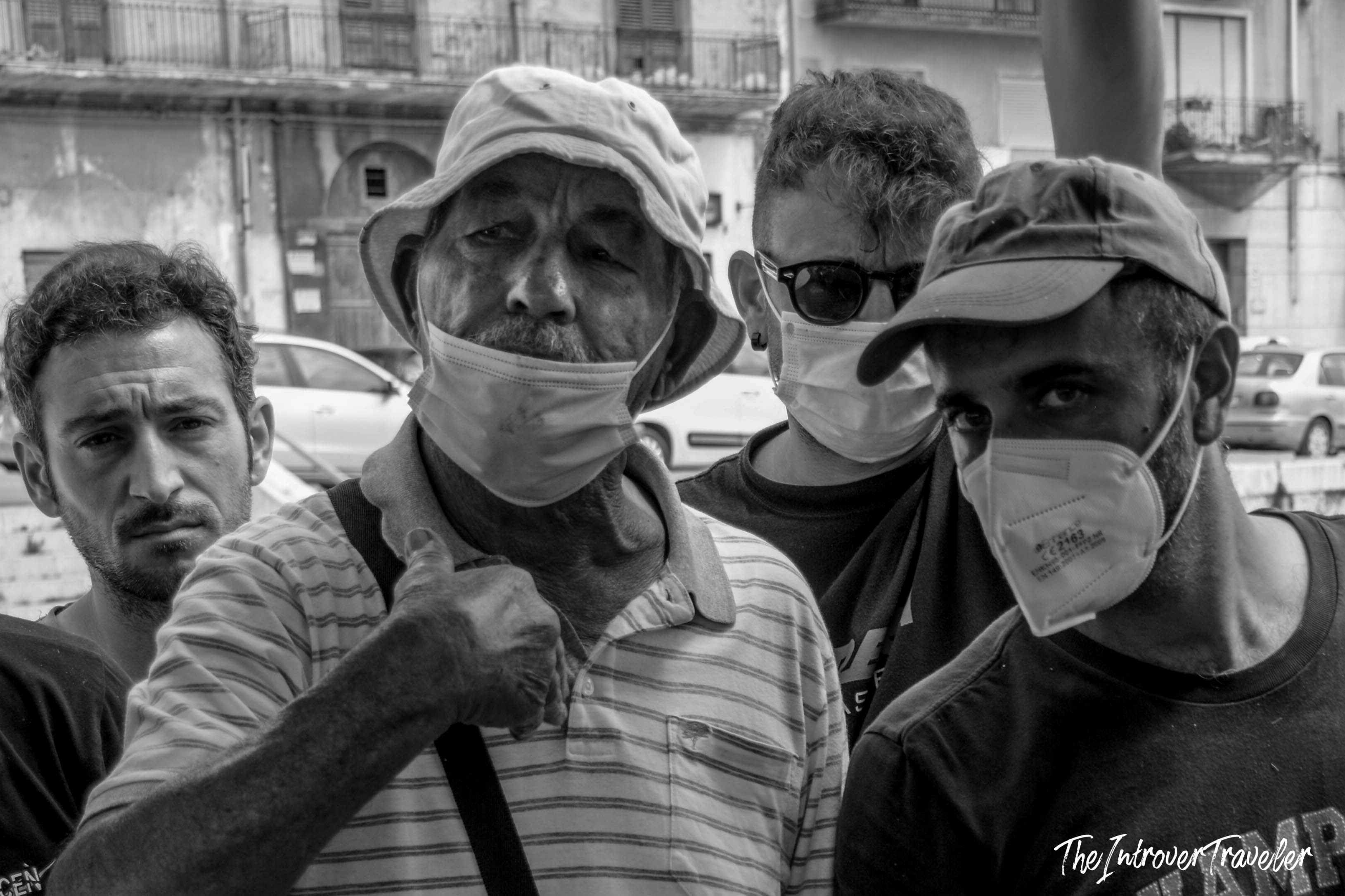 Four local men wearing face masks on a street in Mazara del Vallo, Sicily