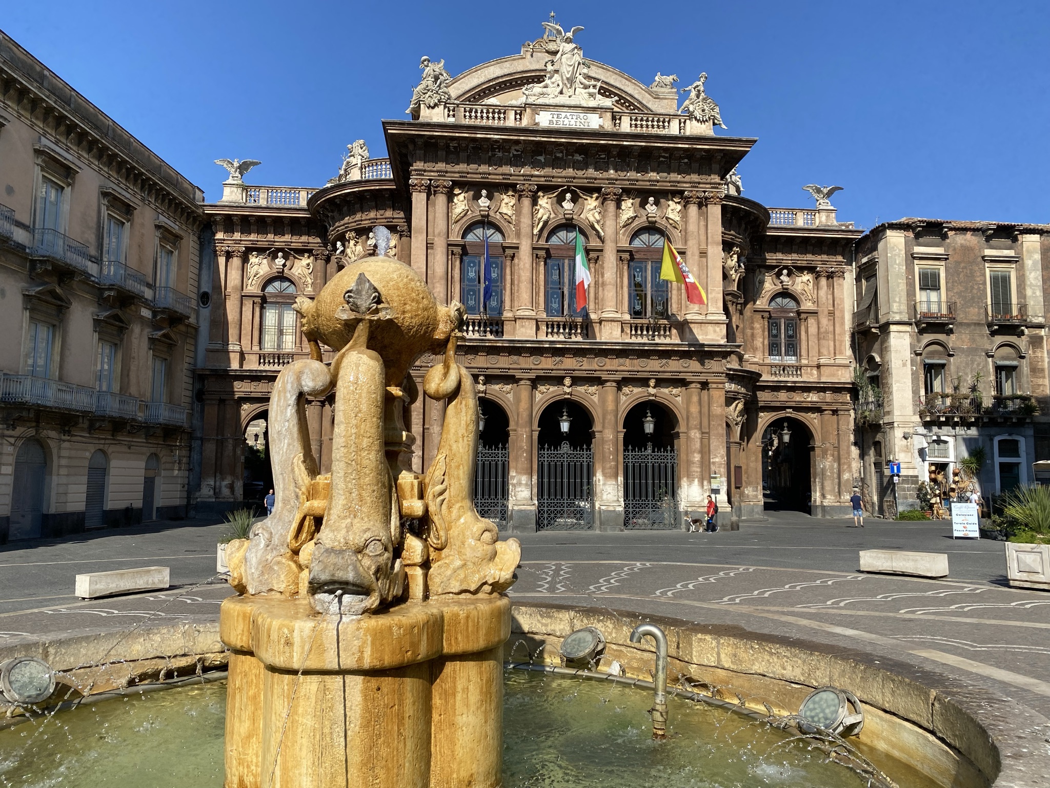 Fountain in Piazza Bellini with the ornate Teatro Bellini opera house facade in Catania, Sicily
