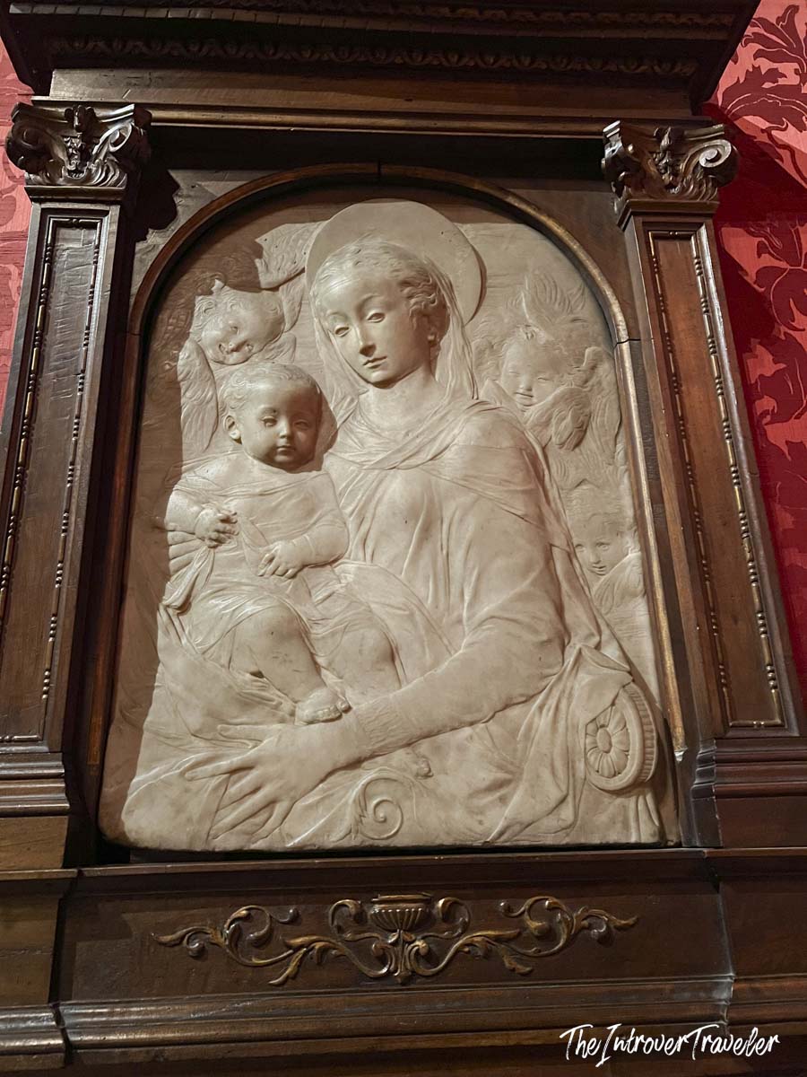 Marble Madonna and Child relief panel displayed in the Morgan Library Museum, set in an ornate carved wooden frame
