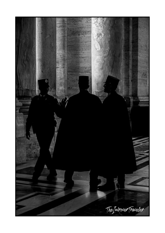 Silhouetted Vatican guards among marble columns inside St. Peter's Basilica, Rome