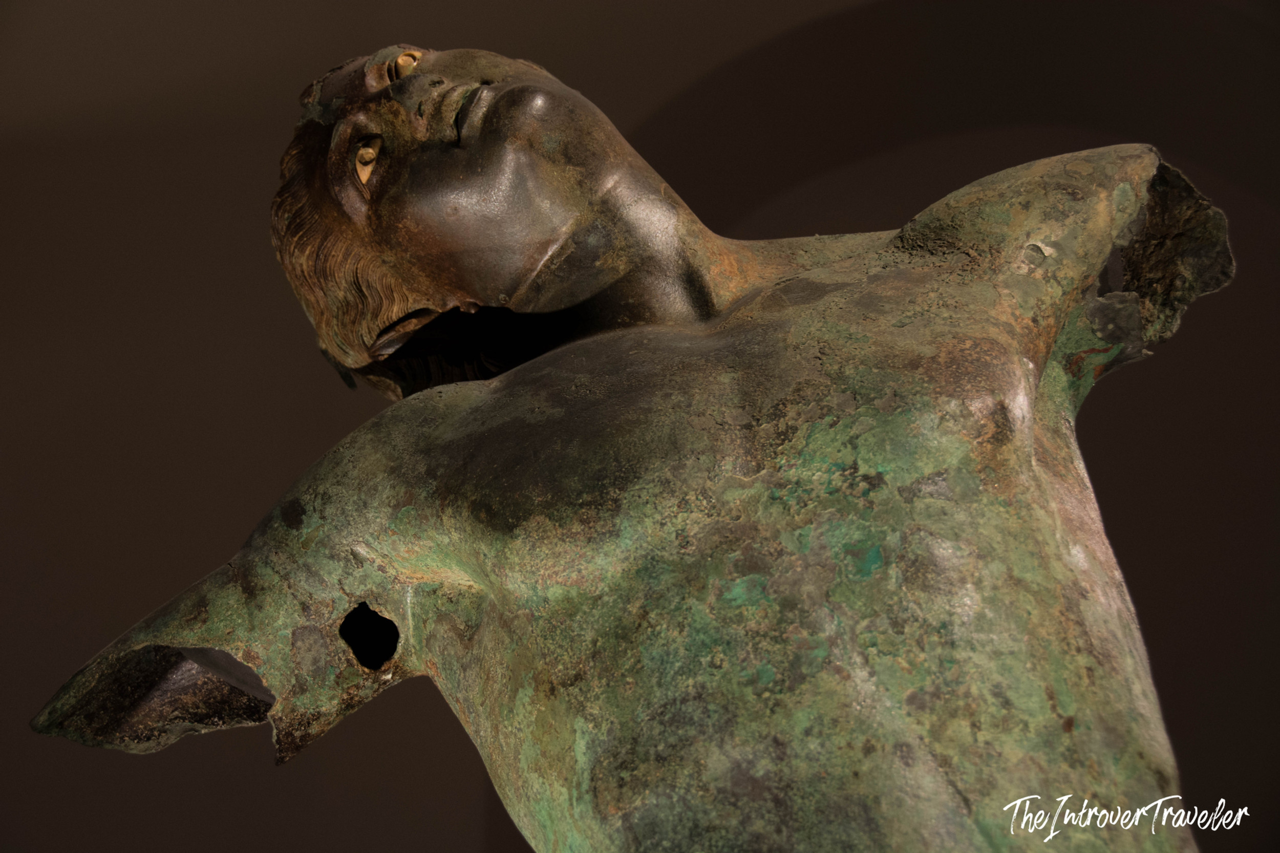 Ancient Greek bronze Satyr of Mazaro del Vallo, close-up of torso and face with golden eyes