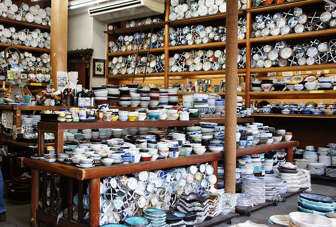 Kappabashi kitchenware shop packed with Japanese ceramic bowls, plates, and tableware on wooden shelves