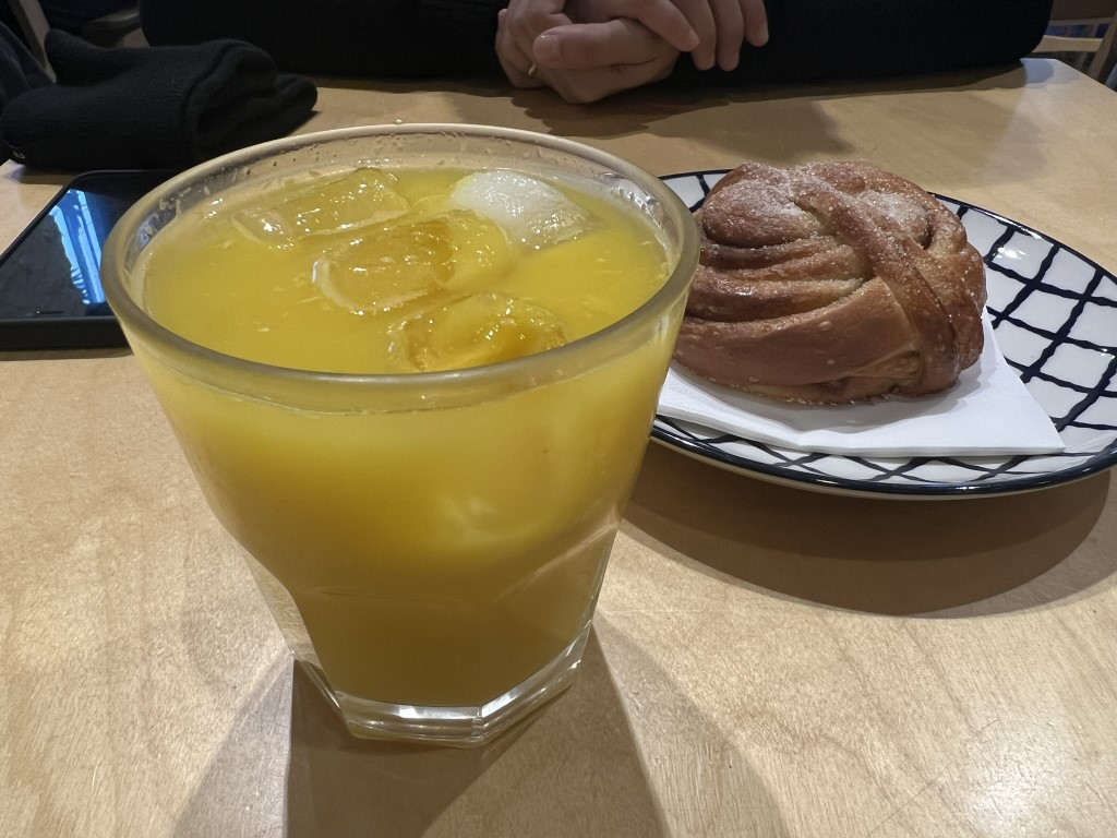 Iced orange juice and a twisted brioche pastry, a signature breakfast duo at Melaleuca Bistrot, Florence
