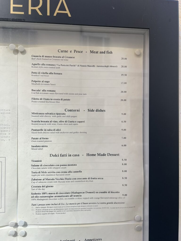 Outdoor menu board at Hostaria Grappolo d'Oro showing Roman meat, fish, sides, and desserts with prices